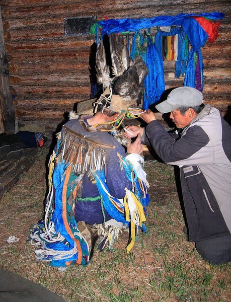 Oktber makes offerings of tea to the shaman