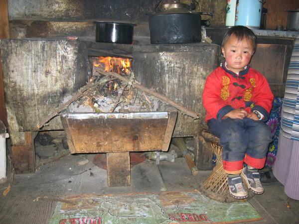 Sherpa boy in front of a stove