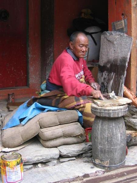 Carver hard at work on Tibetan prayer stones