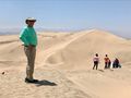Dave stands atop a huge sand dune that overlooks Ica and the Andes mountains behind him