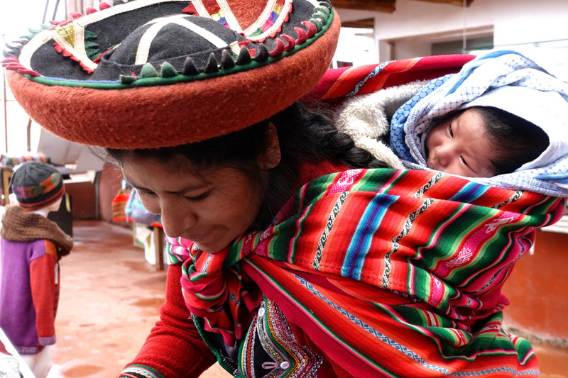 A woman with her child at work at Andean Colors, in the Sacred Valley, Peru 