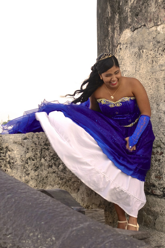 Young woman in a bright blue dress on Cartagena's ancient wall