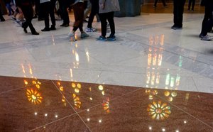 Fanciful light patterns cascade to the smooth marble floor 