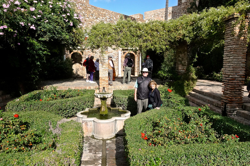 Dave and I are surrounded by myrtle hedges and flowers in the Alcazaba garden