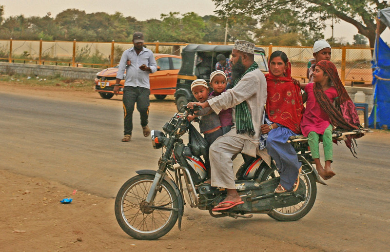 Six-up on a moped and not a helmet in sight!