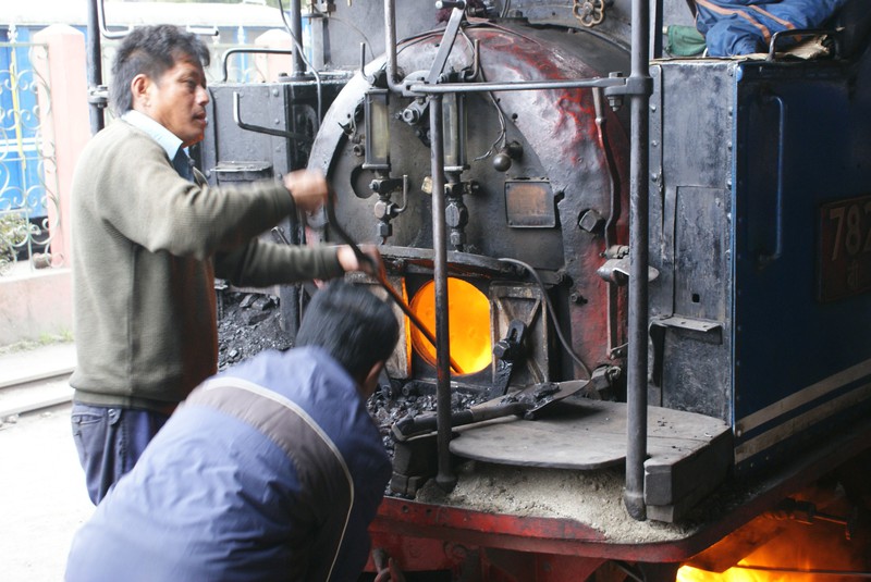 Worker taking out coal from Toy train in Ghum