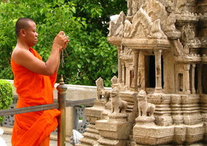 Monk taking a picture of mini-Angkor Wat