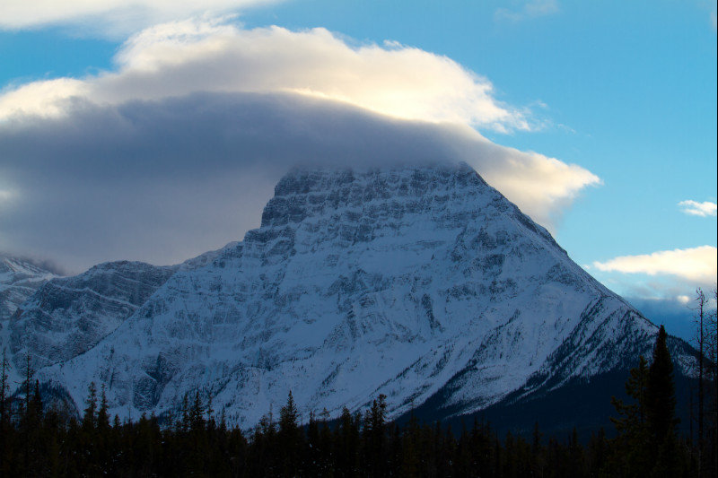 A cloud engulfs a mountain peak