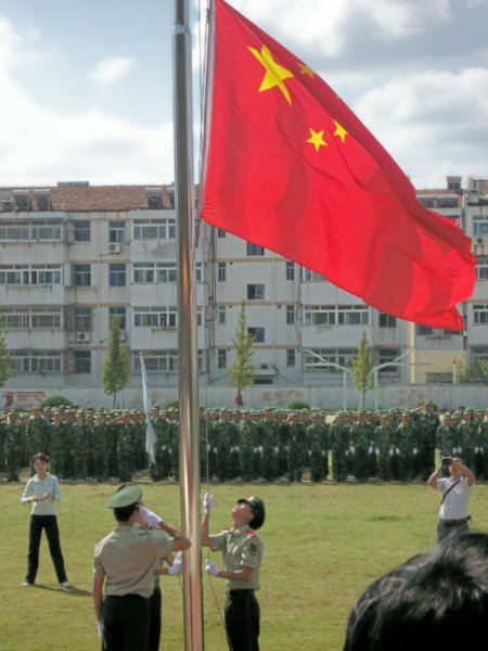 The Chinese Flag is raised and opens the ceremony for the military training ceremony. 