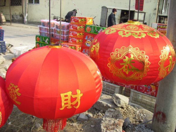 Soon these red and gold lanterns will decorate the doorway of a Chinese home.