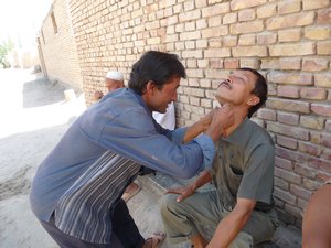 BEYOND KASHGAR, PHOTO 9: Villagers help each other with a "close" shave.