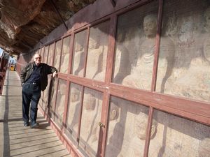 On another covered walkway, the graceful Buddhas have been protected from additional vandalism.