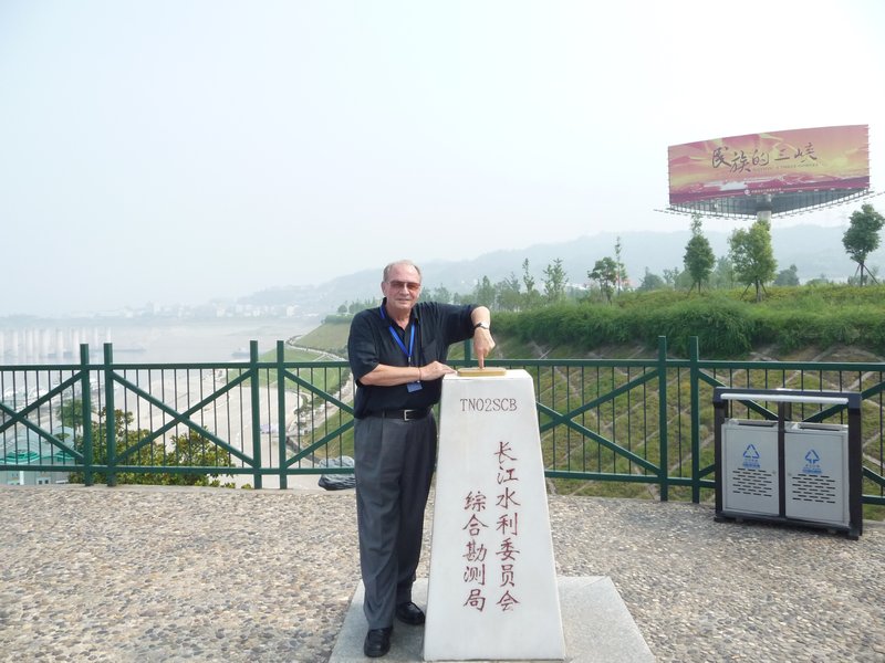 We are on top of a hill at a corner stone, with the Three Gorges Dam behind us in the fog.