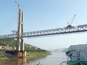 Back on board, the ship cruises under newly constructed bridge, on its way to the city of Chongqing.