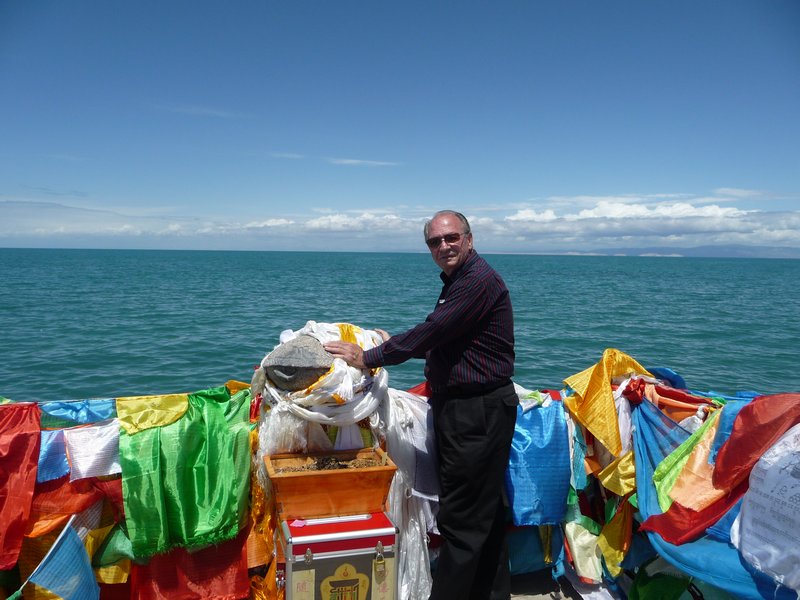 Colorful Tibetan Prayer Flags are offered by the faithful along the shores of Qinghai Lake