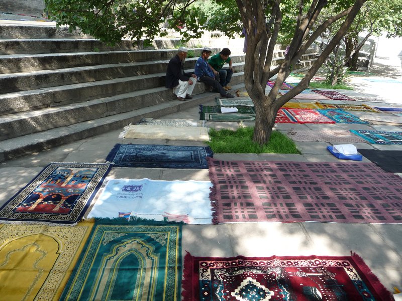 The shady spaces of the courtyard of the Great Mosque are quickly reserved by prayer rugs.