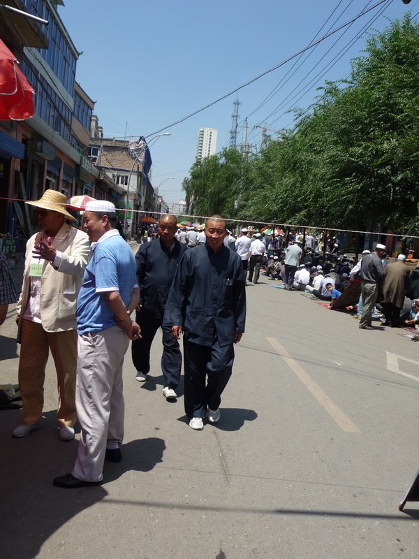Taoist priests walk the Muslim quarter of Xining, Qinghai