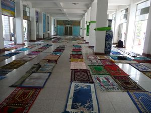 The front entrance hall is already reserved by a sea of prayer rugs.