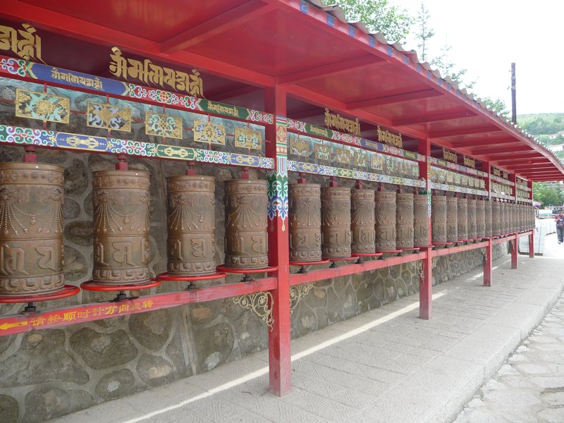 Walking toward the Ta'er Si, I pass a row of Tibetan prayer-wheels.