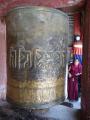 Giant prayer-wheel is turned by Buddhist monk.