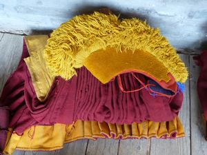 The robes of a Yellow Hat Sect Buddhist monk are neatly folded in a corner.