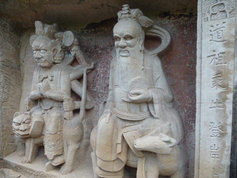 Dao Sages at the entrance of the walking path, that takes visitors around a horse-shoe of thousands of stone carvings.