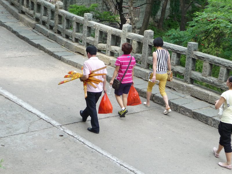 Pilgrims and visitors carry incense and gifts as offerings for the many shrines along the mountain route of Tai Shan.