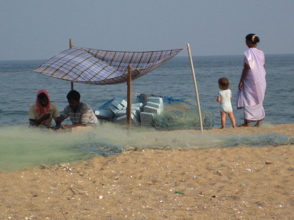 Mending fishnets on repos beach