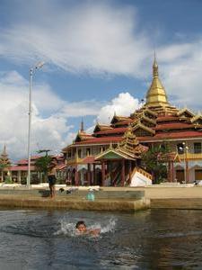 Young boys swimming in front of one of the biggest pagodas