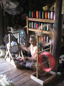 Old lady working on a spinning-wheel