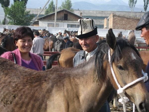 Old man in an 'ak kalpak' (felt hat) checking out a horse