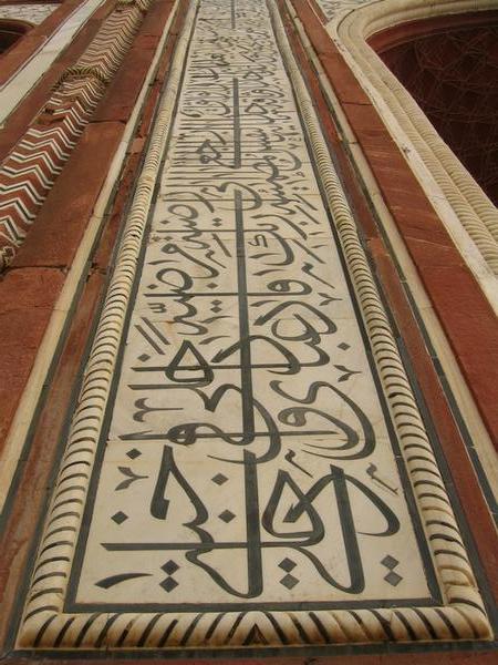 Close-up of Koranic inscriptions on the gate