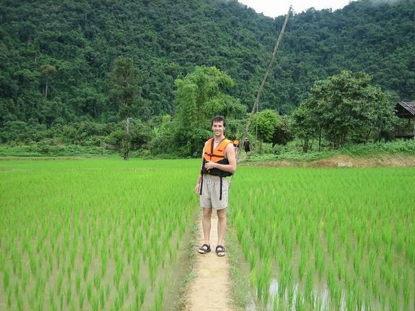 Casto walking through the ricefield on the way to the caves