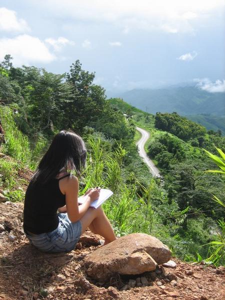 Jen writing in her journal during a long holdup on the road to Luang Prabang