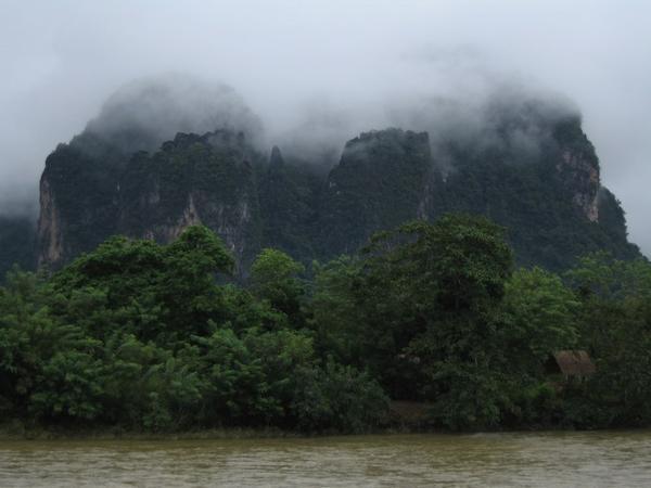 View from our bungalow, out over the Nam Song river to the mist-draped karst cliffs