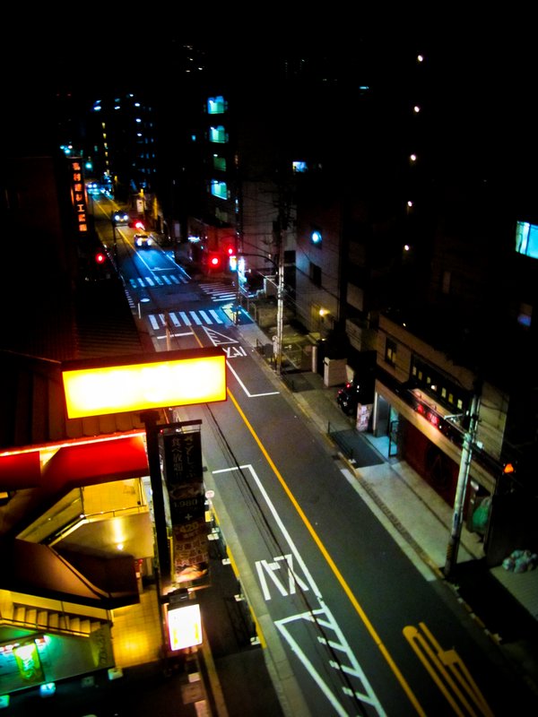 Same street at night. The red sign says "Japanese Restaurant"