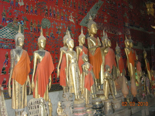 Buddha statues against a spectacular mosaic wall