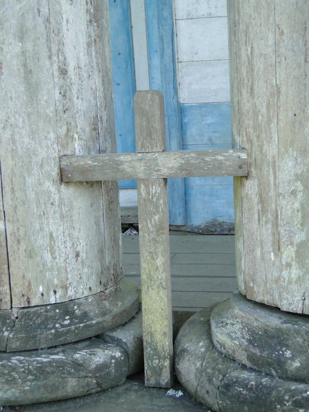 A simple cross outside a wooden church