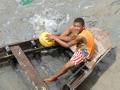 Young Boy Clearing the Water from his Boat