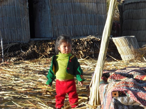 A child with the colourful clothes on the floating islands of Puno.