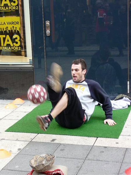 street performer doing crazy tricks with a soccer ball
