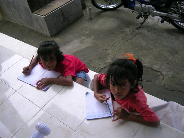 The twins doing their homework on the front step.