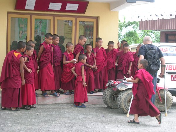 Young monks fascinated by a 3 wheeler motorbike.