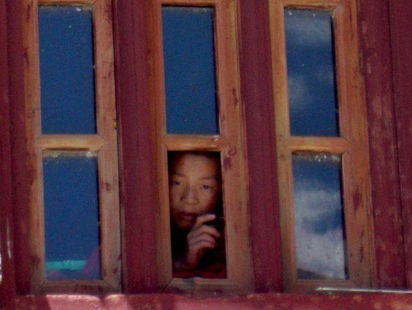 Monk peering out a window
