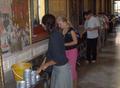 Dropping coins in the bowls at Wat Pho