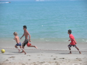 Nam and German Kids Playing Soccer On the Beach