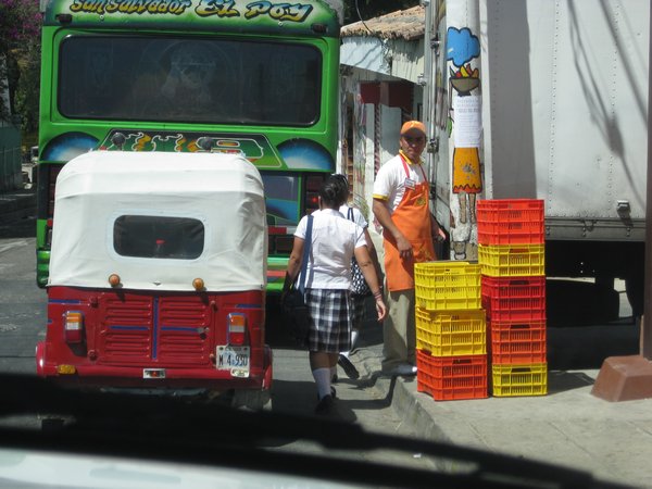 Here we have a school girl, a colorful bus, a taxi and a shopkeeper.