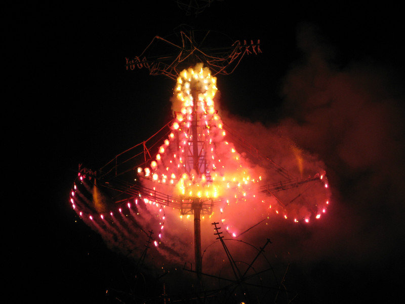 The pyrotechnics were attached to wooden stands in the street mere feet from the large crowds watching from the adjacent park.