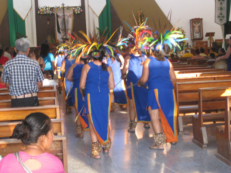 Aztec dancers being blessed in the church.