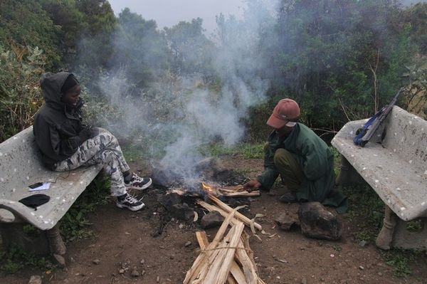 Ethiopia watches the scout, Desarie, stoke the fire - Simien Mountains, Ethiopia
